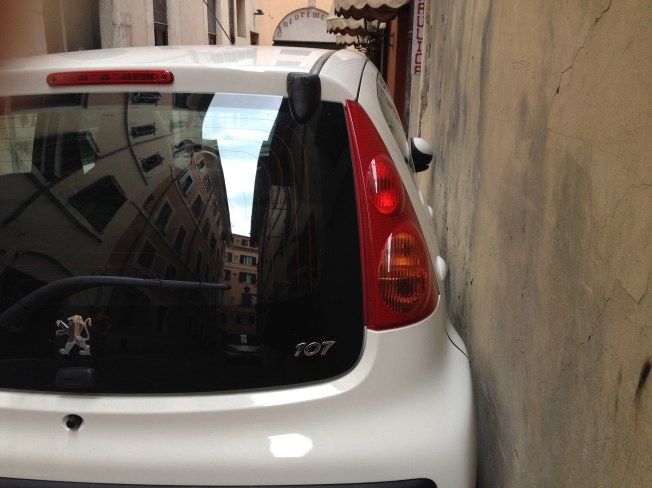 A car barnacled to the wall outside the Hotel Due Torri in Rome