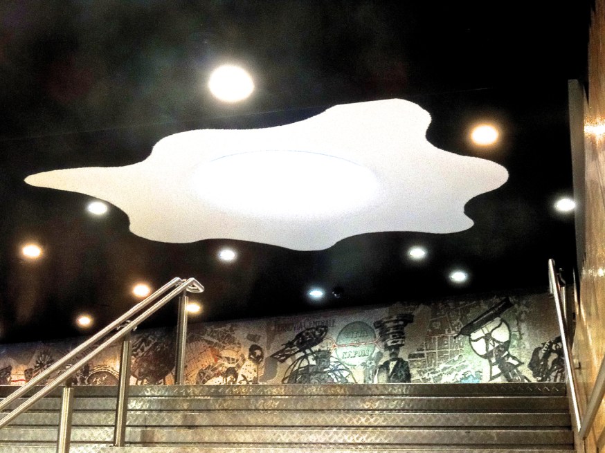 A view from just below the entrance hall of the Toledo metro with glimpses of the William Kentridge mosaic: "Central Railway for the city of Naples, 1906 (Naples Procession), 2012 Stone and glass paste mosaic."