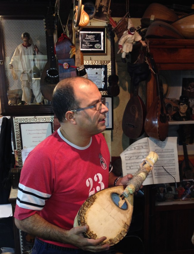 Luthier Salvatore Masiello explaining the making of the mandolin to the crowd in his tiny 'bottega' in Naples, Italy