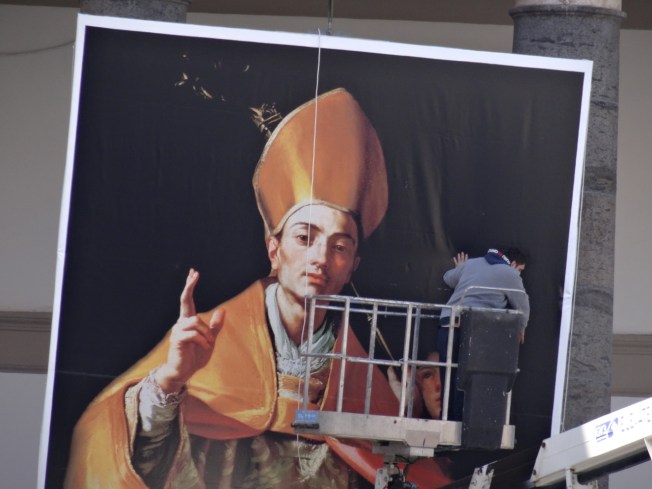 A large poster of San Gennaro is raised in Piazza cel Plebiscito for the Pope's visit in March 2015