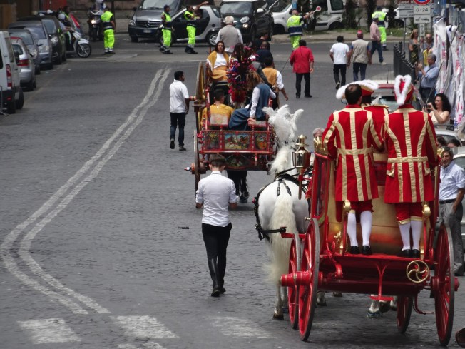 The carriages make their way back through the traffic in Naples, Italy