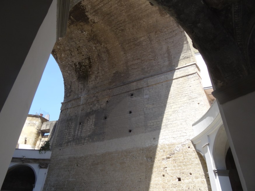 The leg of the bridge that stomps through the middle of the curved cloisters of the Basilica di Santa Maria della Sanità in Naples, Italy