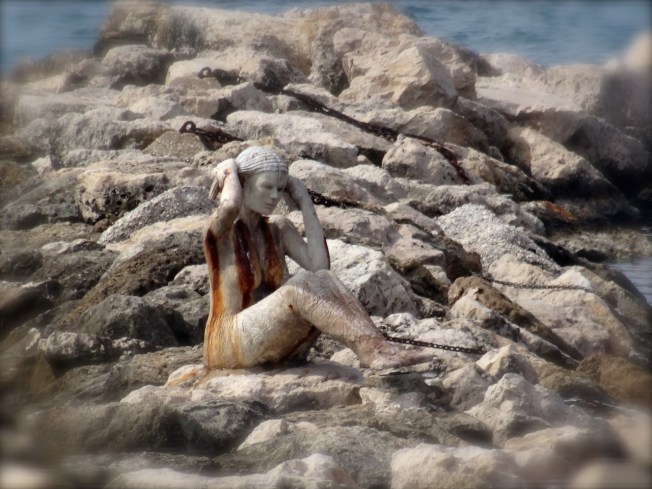 A siren on the rocks in Taranto, in Puglia, Italy