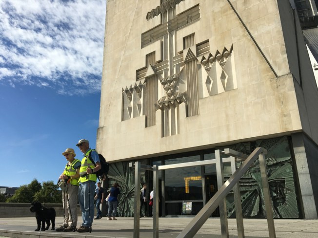 The end of the 2017 Hull to Liverpool fundraising walk for ZANE - Tom and Jane Benyon with Moses in front of the Metropolitan Cathedral of Christ the King in Liverpool