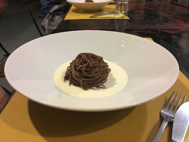 Chocolate pasta dipped in rosemary oil served on a cream and Parmigiano sauce